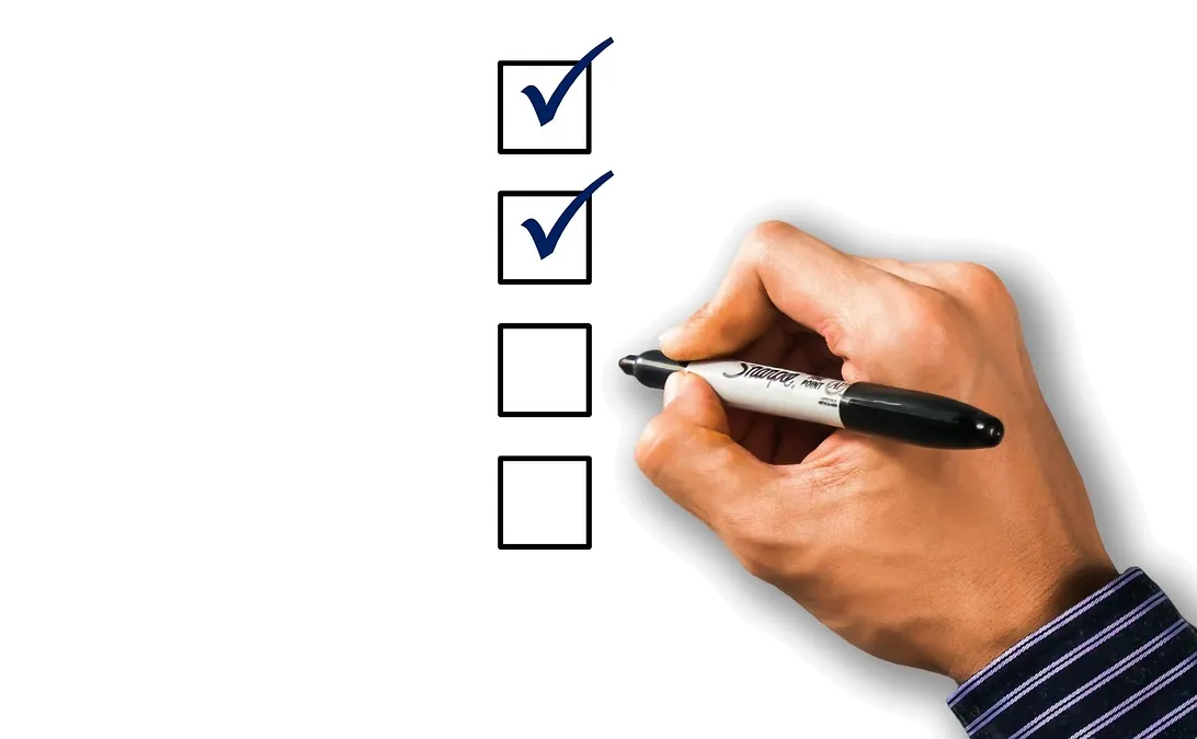 A hand ticking off a checklist with a pen, illustrating the steps to test Claude Skill before giving it to your team