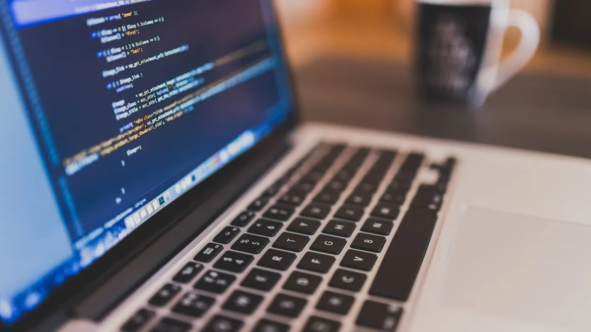 Close-up of a laptop showing code in a dark text editor — what it looks like to write a SKILL.md file