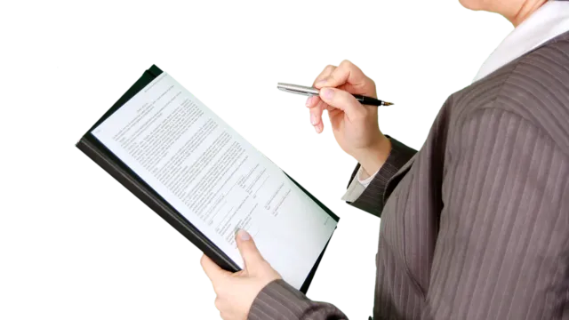 Businesswoman reviewing documents on a clipboard — reviewing a company SOP before turning it into a Claude skill