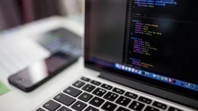 Developer writing code in an editor on a laptop screen, illustrating the Continue.dev VS Code tutorial