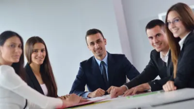 Sales and marketing team meeting around a table reviewing campaign strategy — Copy.ai review