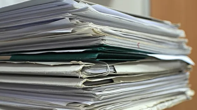 Stack of office documents and folders on a desk to summarize PDFs with AI