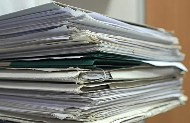 Stack of office documents and folders on a desk to summarize PDFs with AI