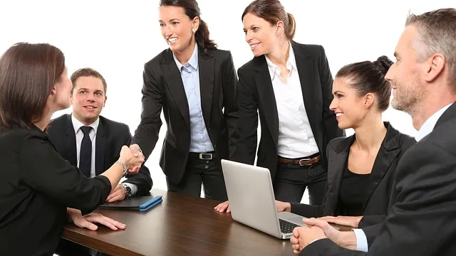 Business team shaking hands at an office meeting across a desk, illustrating how small teams can try ready-made agent skills
