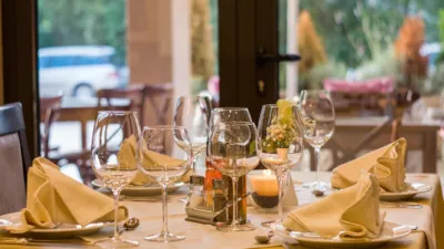 Elegant restaurant table setting with wine glasses and folded napkins — the kind of dining room Yelp Smart Lead Reply's Check for Me phone agent calls to check wait times