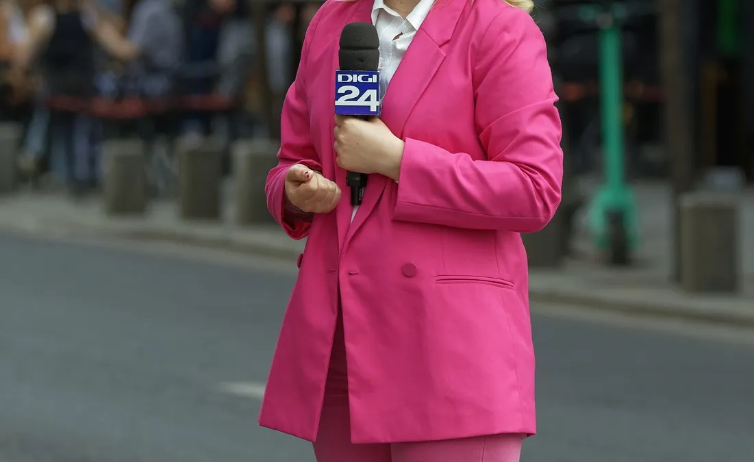 TV reporter in a pink suit with microphone on a Bucharest street, illustrating a presenter for a HeyGen review