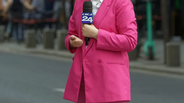 TV reporter in a pink suit with microphone on a Bucharest street, illustrating a presenter for a HeyGen review